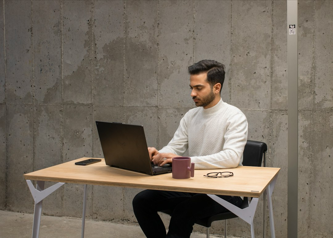 A person working on a laptop at a table.